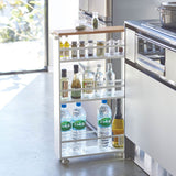 ハンドル付きスリムワゴン タワー(ホワイト)にボトルや調味料を収納したシーン