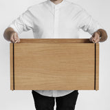 ストレージボックスを男性が両手で持った様子