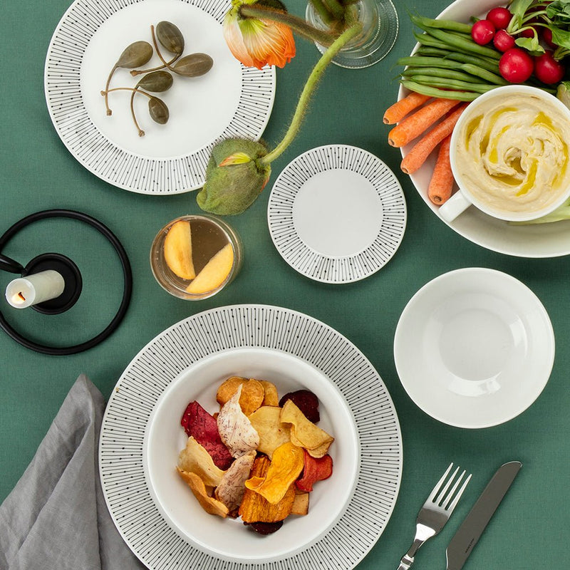 マイニオ サラストゥスシリーズの食器に野菜やチップスを盛り付けた食卓