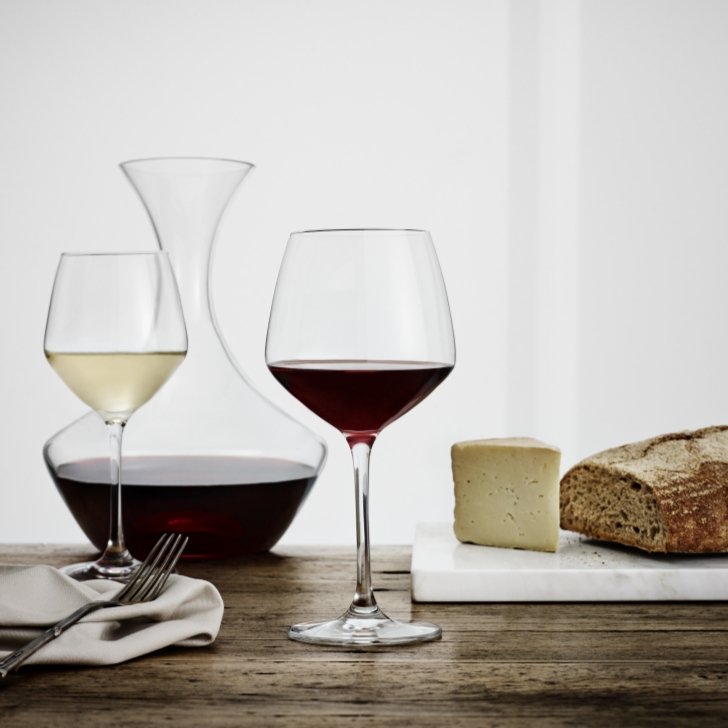 ワインが入ったパーフェクション ブルゴーニュグラスとカラフェ、食べ物をテーブルに置いたイメージシーン