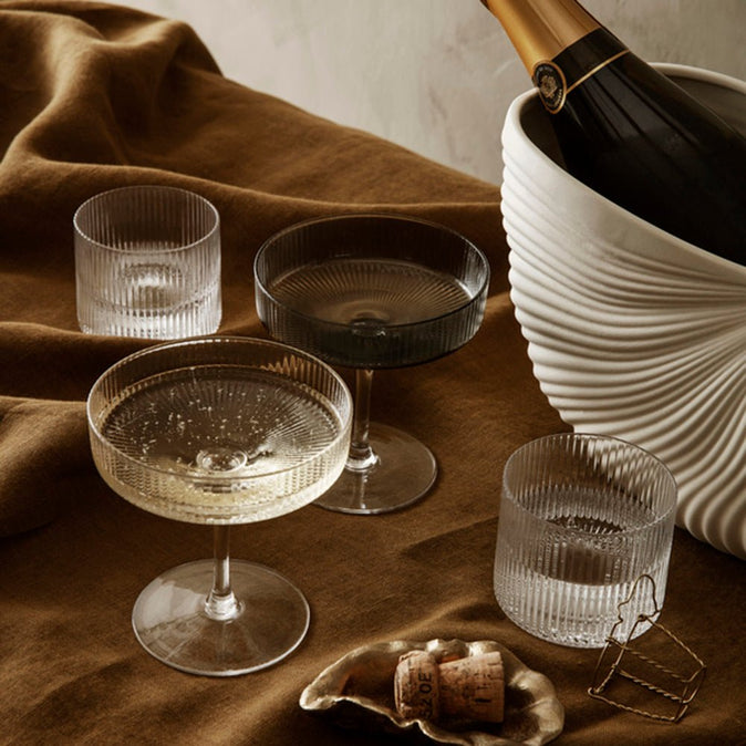 リップルシャンパンソーサー クリアとスモークにシャンパンを注いでテーブルに並べたイメージシーン